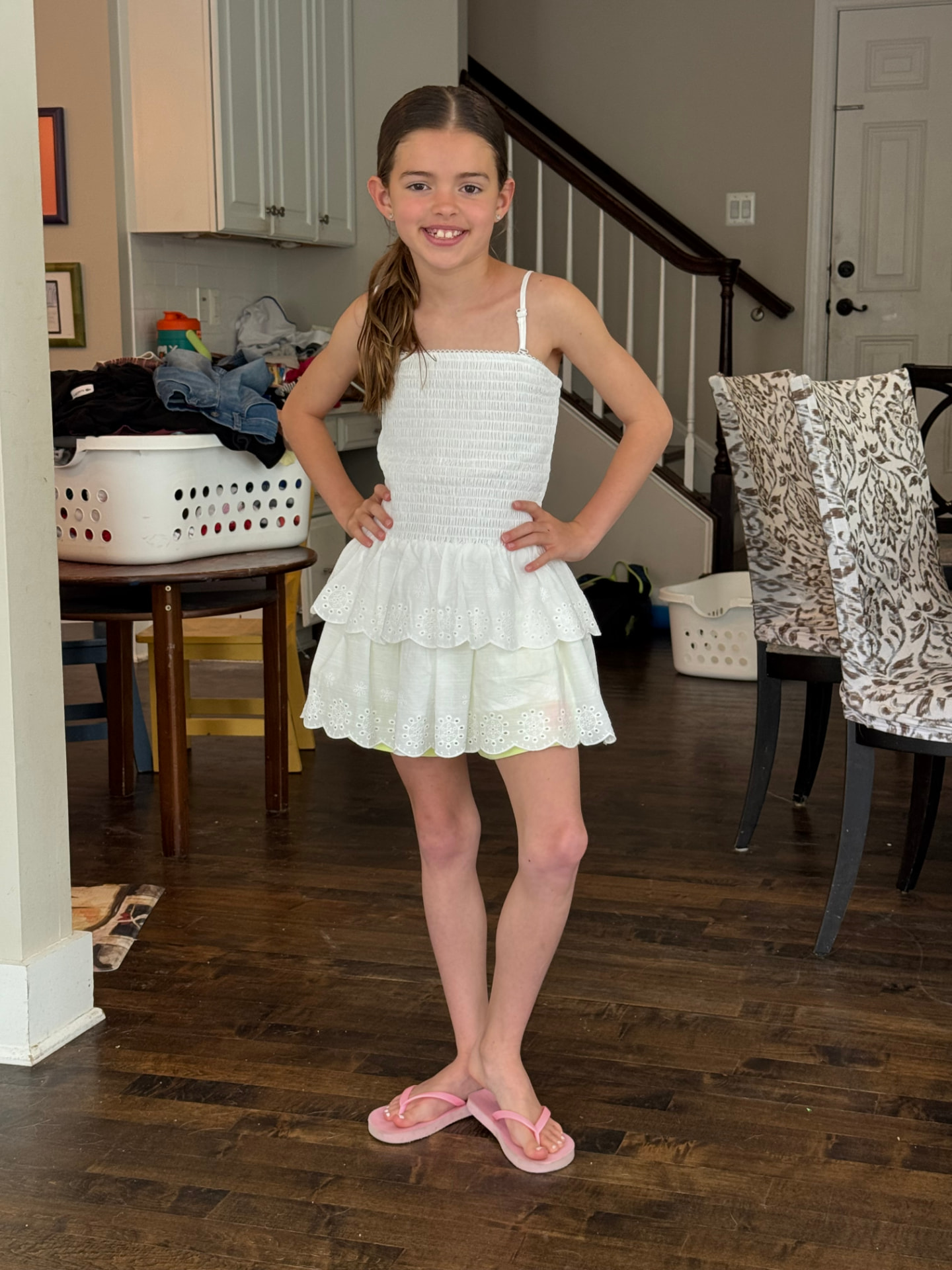 Paige in a white eyelet dress and pink flip flops